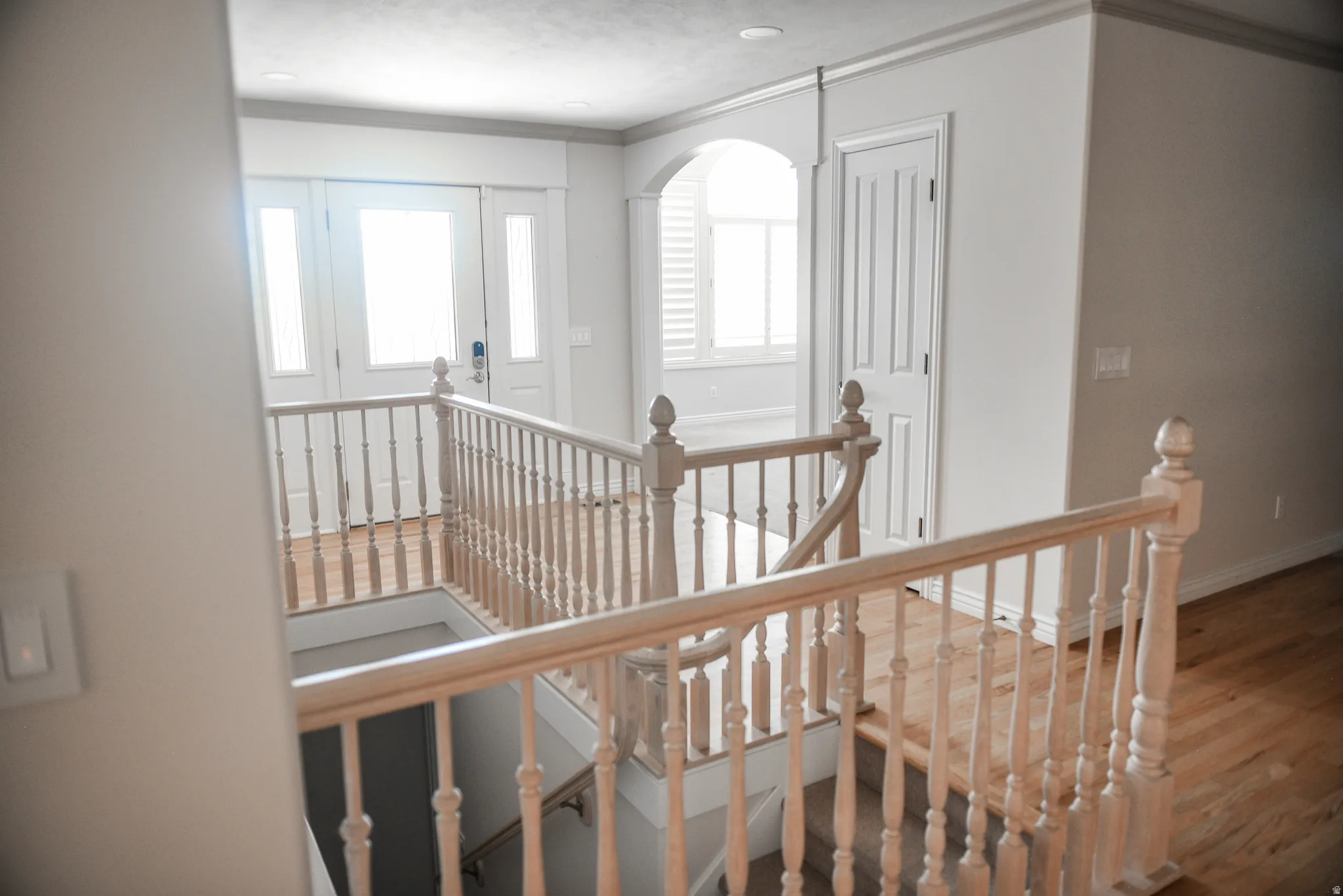 Upper-level landing with wood-finish flooring and a light wood balustrade