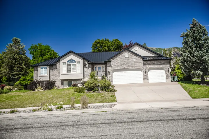 Stone-clad exterior featuring a prominent arched window and a dark metal roof