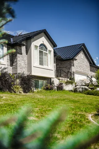 Stone veneer siding exterior with a dark metal roof