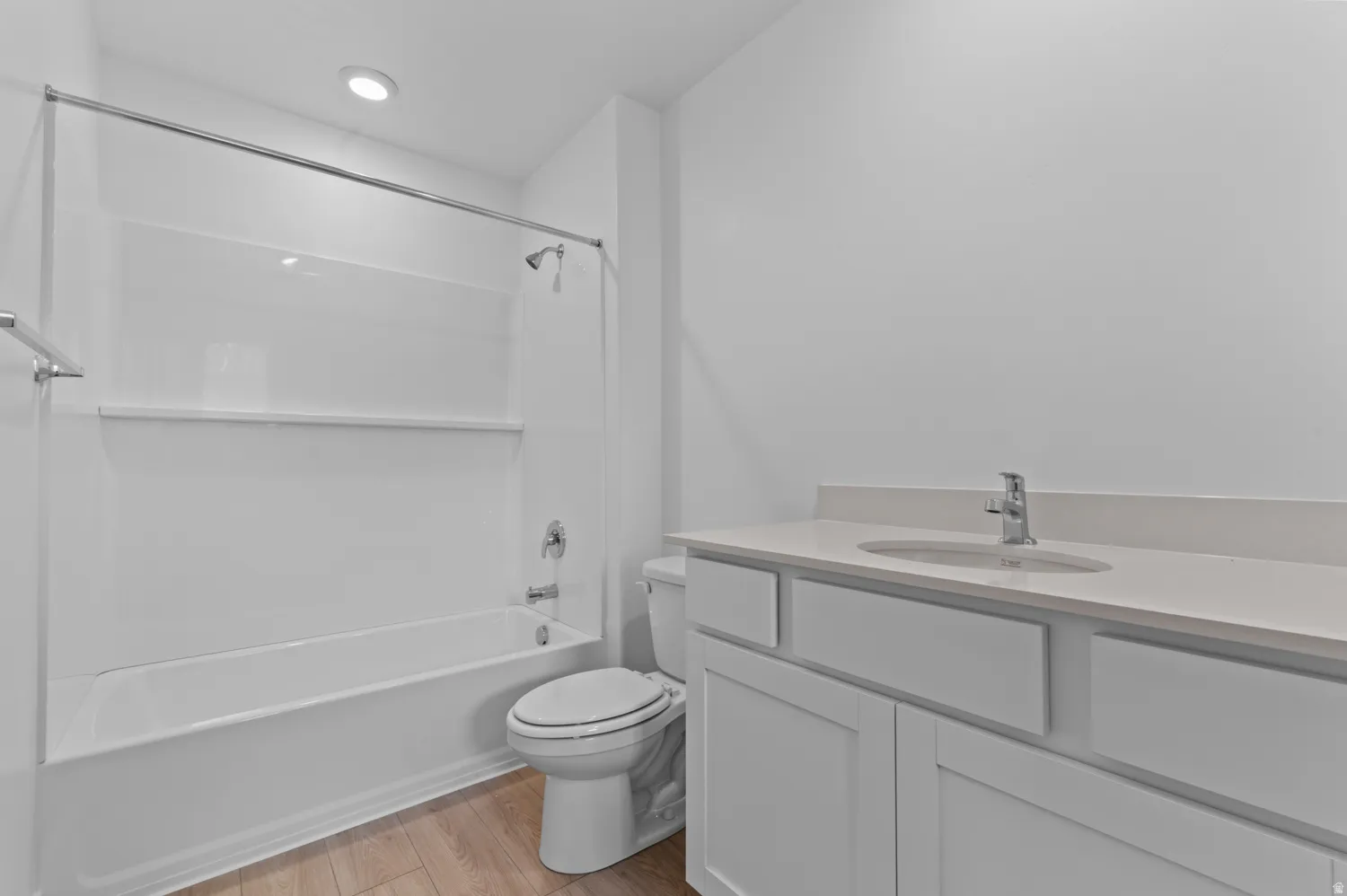 Bathroom featuring a white vanity with slab countertop, undermount sink, and chrome faucet