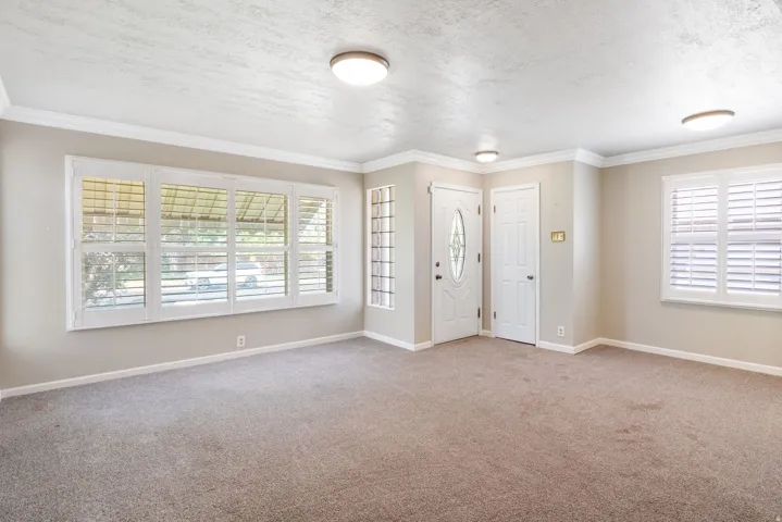 Spacious room featuring neutral carpeting and light-toned walls