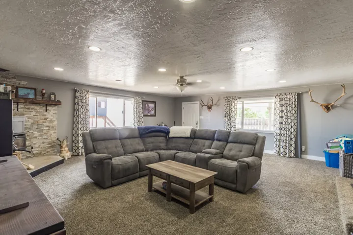 Spacious room featuring neutral carpeting, recessed lighting, and multiple windows