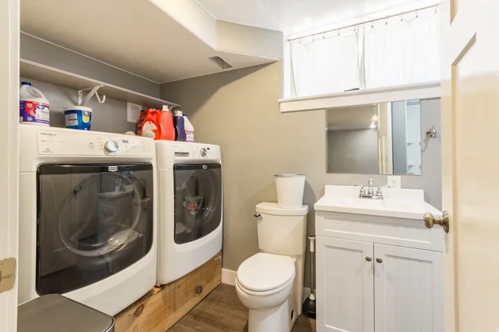 Dedicated laundry area featuring front-loading machines and an overhead shelf