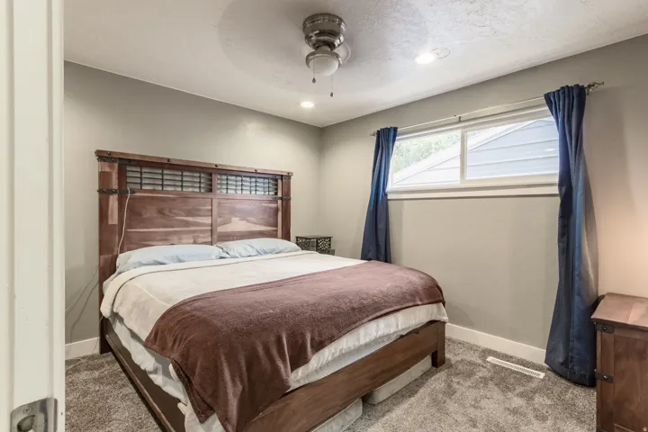 Carpeted bedroom featuring a ceiling fan, recessed lighting, and a long window