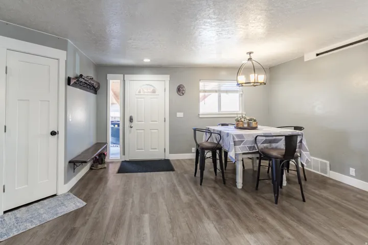 Entryway with wood-finish flooring, a white paneled door, and a built-in wooden bench