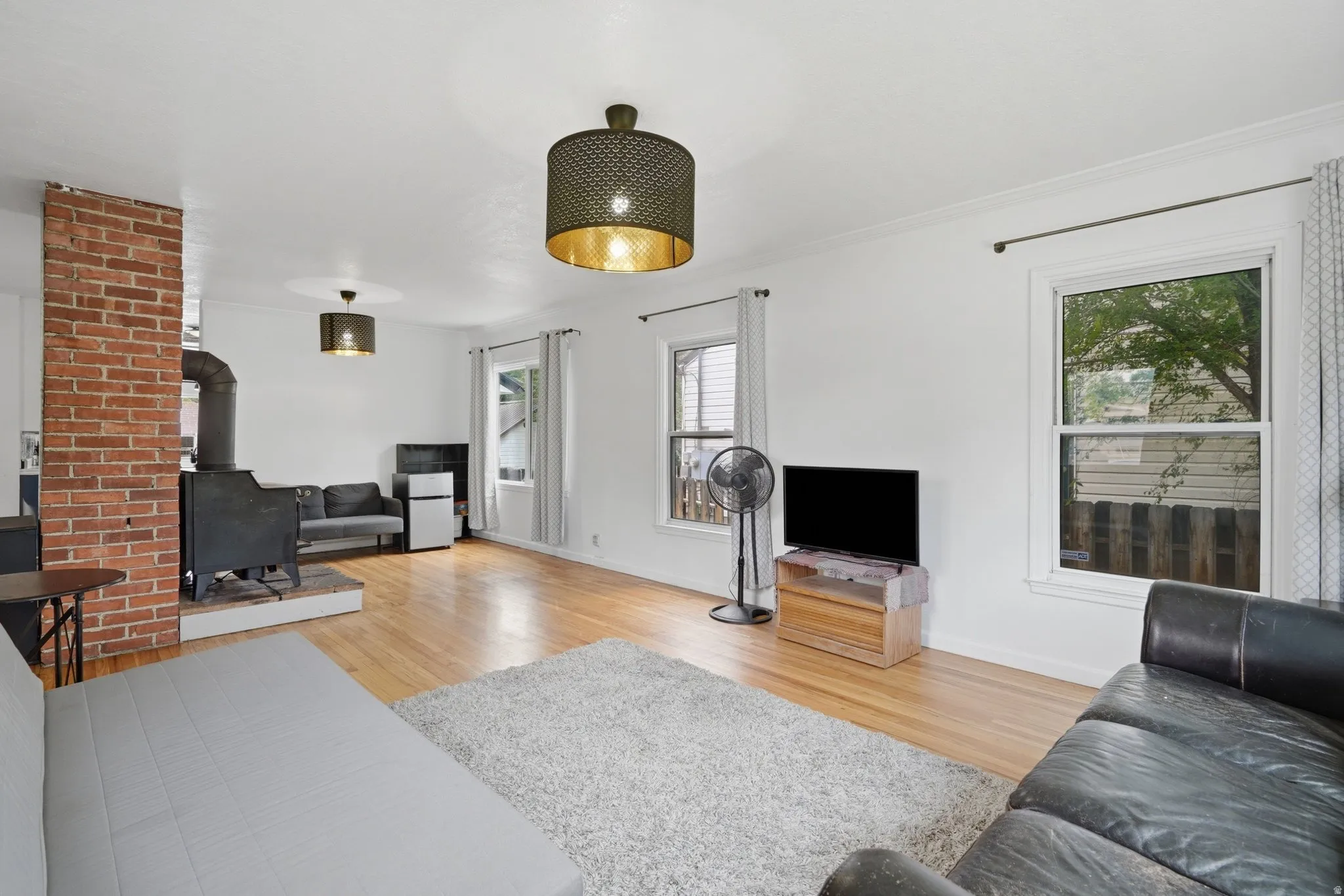 Spacious interior featuring wood-finish flooring, white walls, and multiple windows