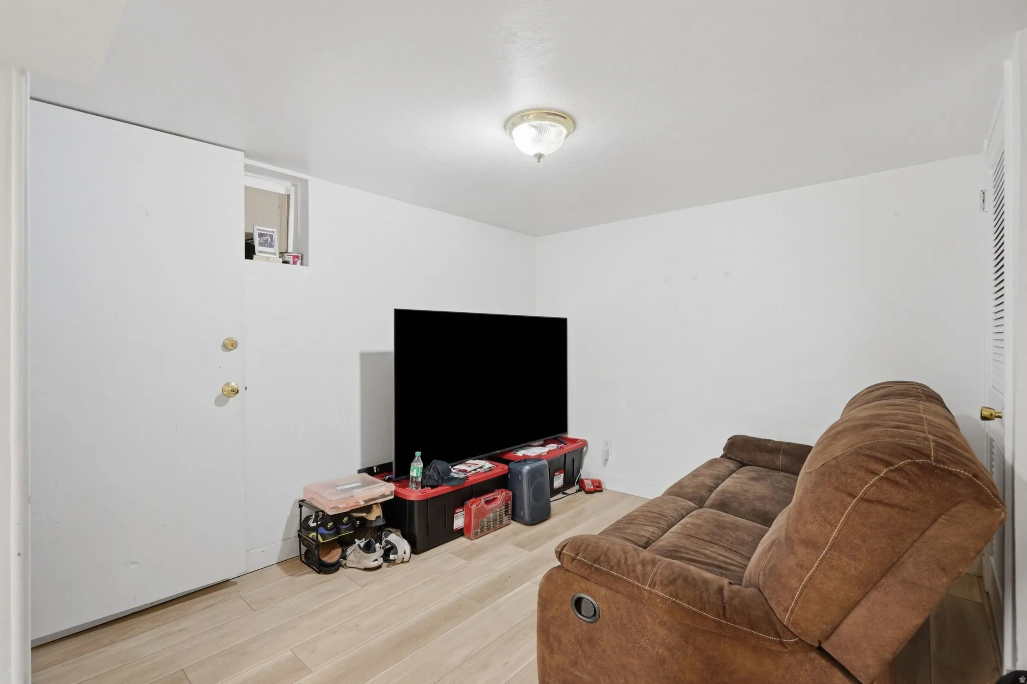 Light-colored wood-look flooring with a flush-mounted ceiling light fixture
