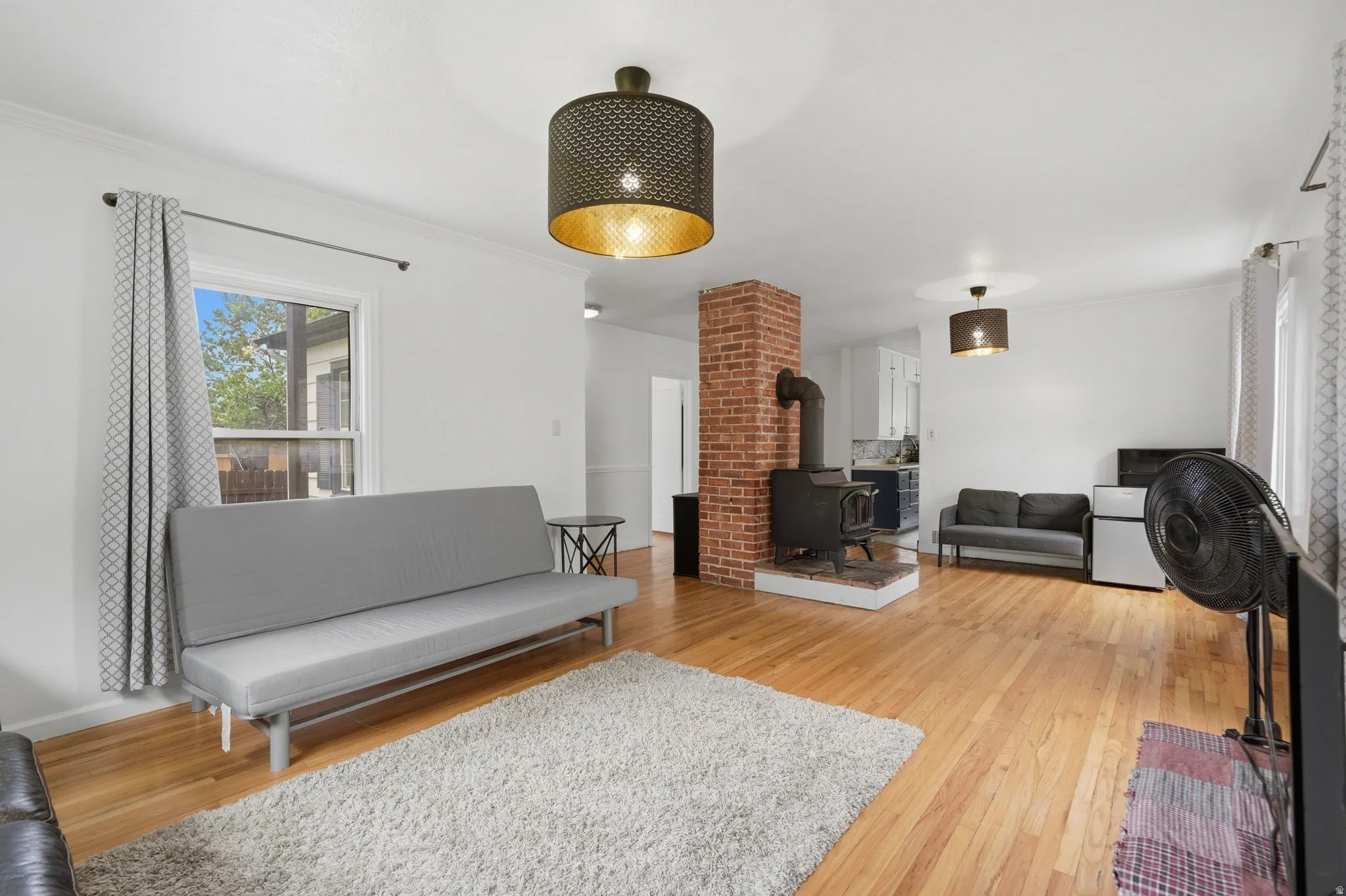 Expansive open living space featuring wood-finish flooring and white walls