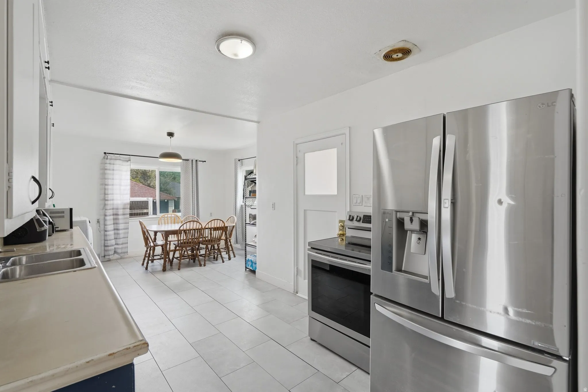 Kitchen featuring stainless steel appliances, tile flooring