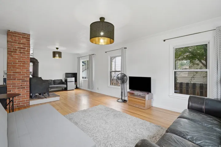 Spacious interior featuring wood-finish flooring, white walls, and multiple windows