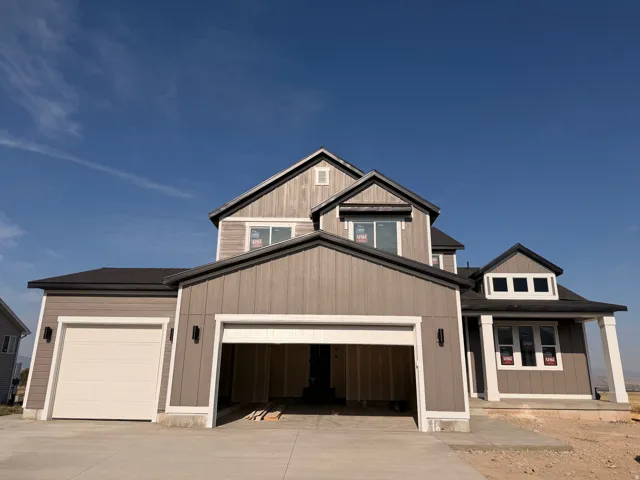 Contemporary exterior with gray vertical and horizontal siding, dark roof, prominent white trim, and a two-car garage
