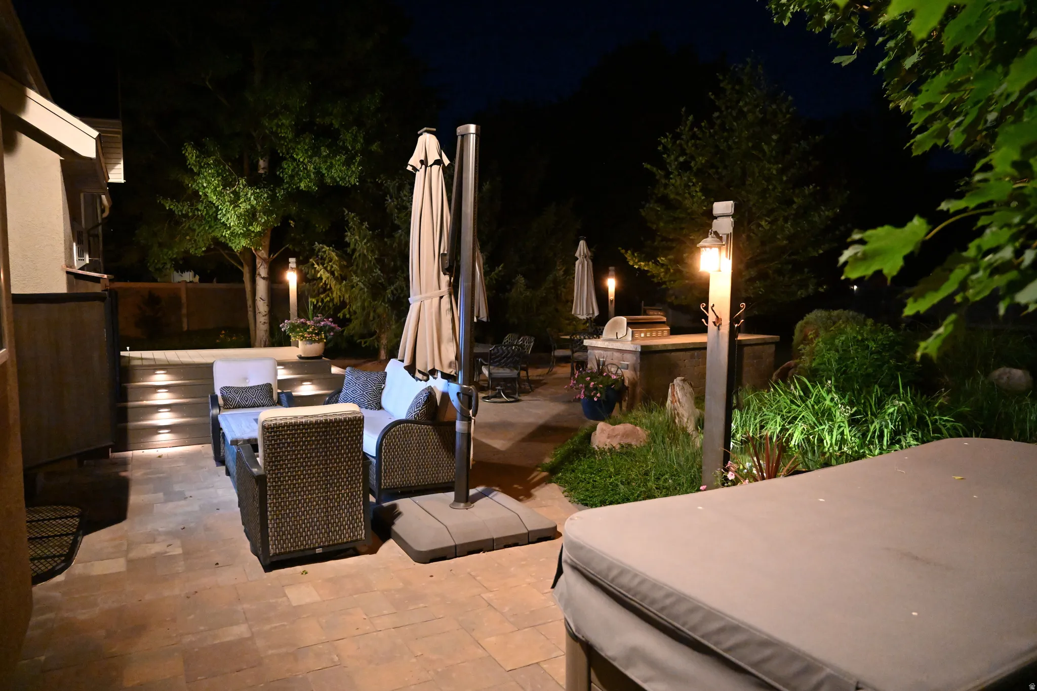 Expansive paver patio with tiered hardscaping and integrated step lighting