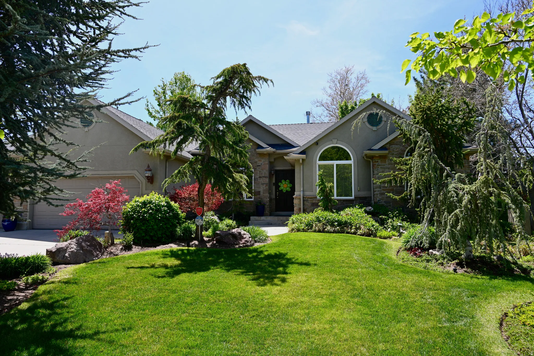 Stucco and stone exterior featuring a prominent arched window and a circular attic window