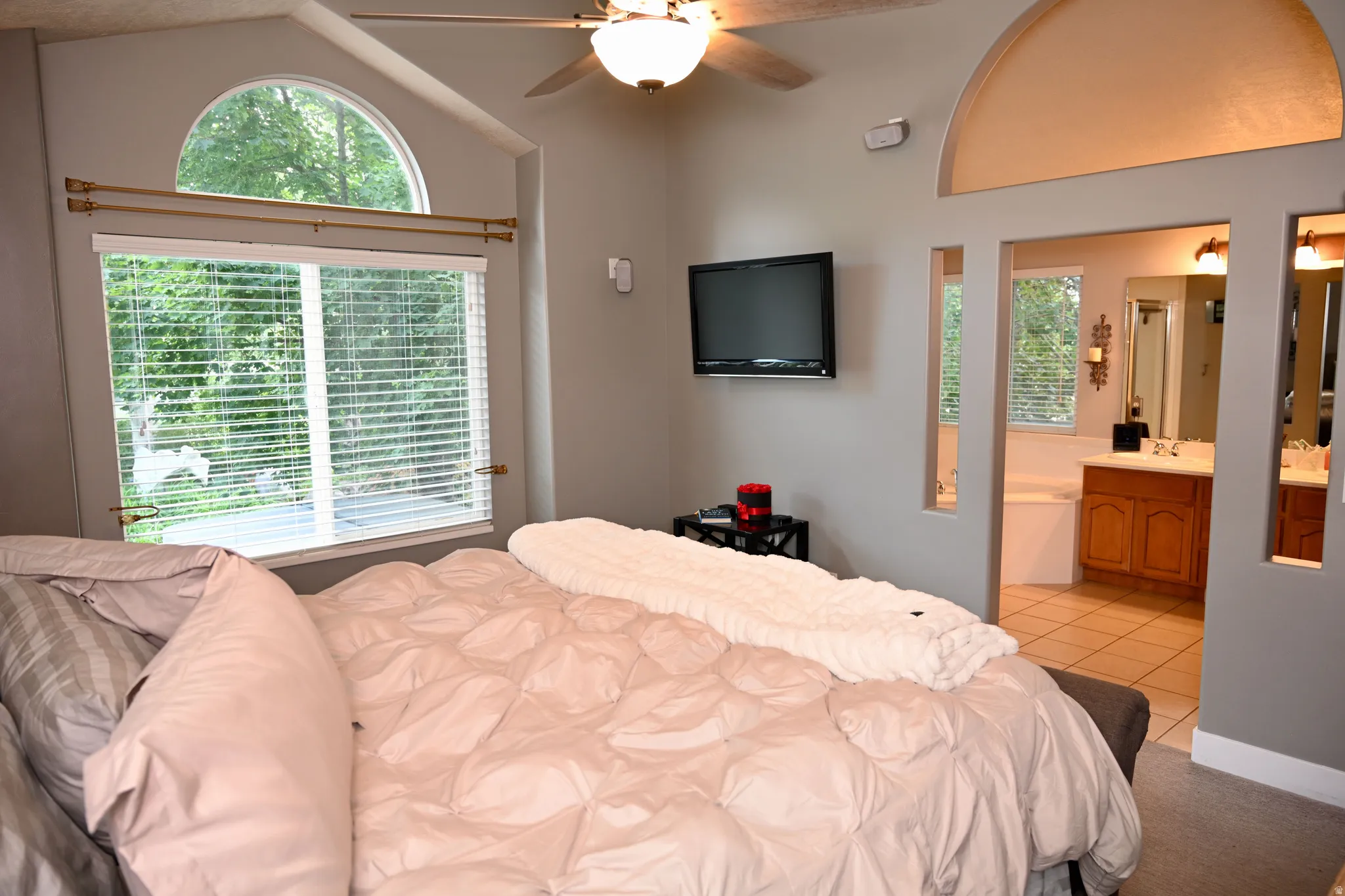 Bedroom featuring a vaulted ceiling and a ceiling fan with integrated lighting