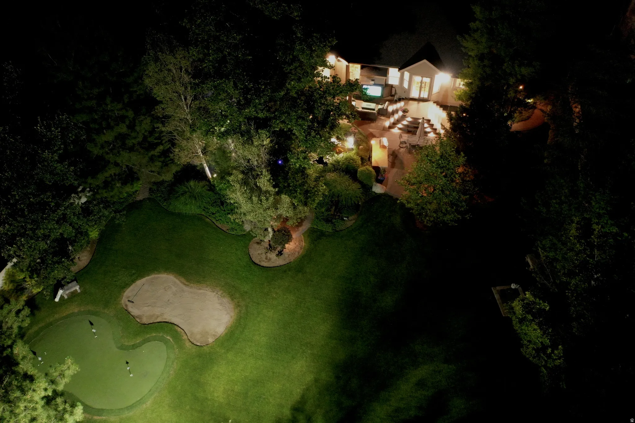 Expansive outdoor recreation area featuring a putting green, sand trap, and manicured lawn
