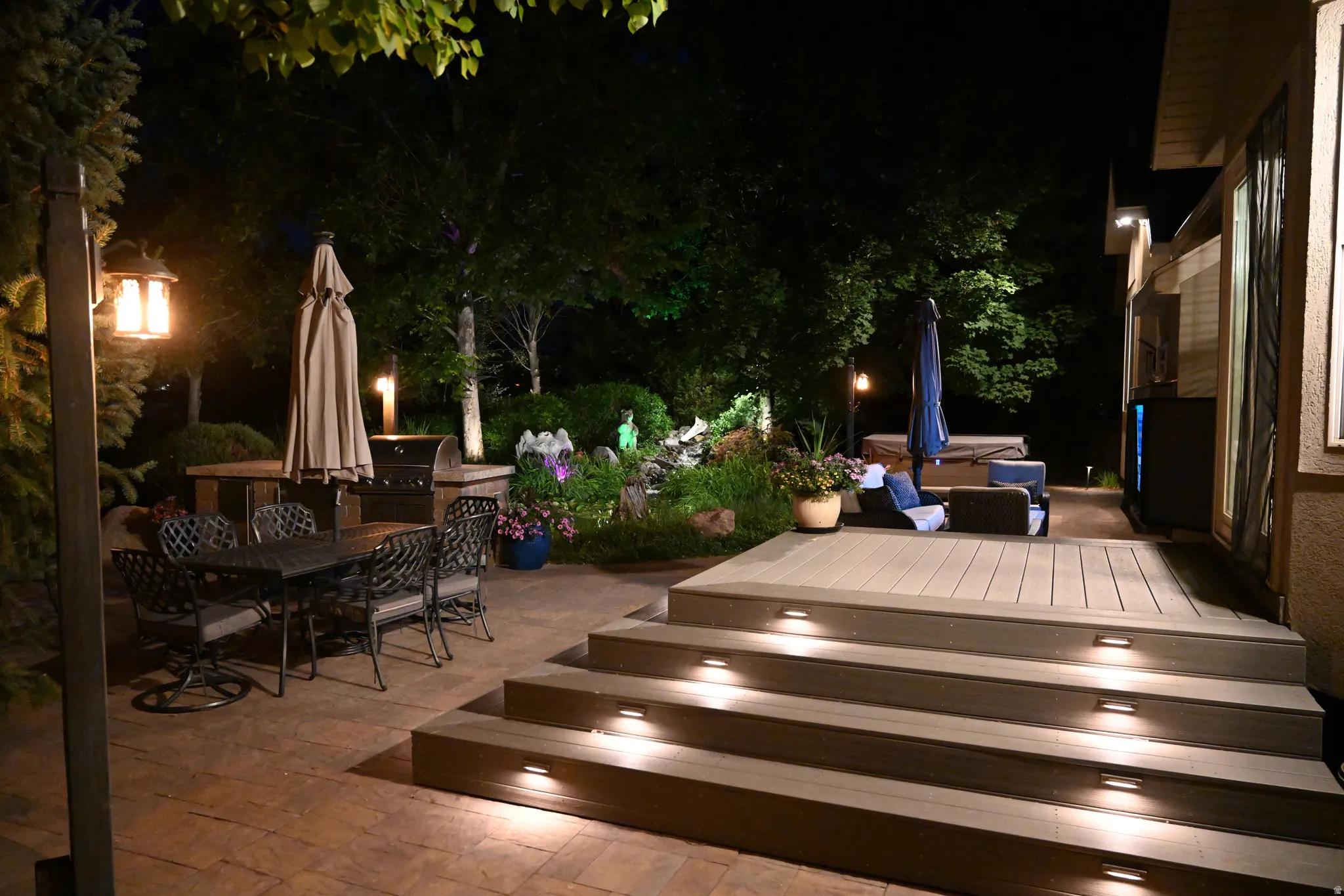 Multi-level outdoor living space featuring a paver patio and a composite deck with integrated stair lighting