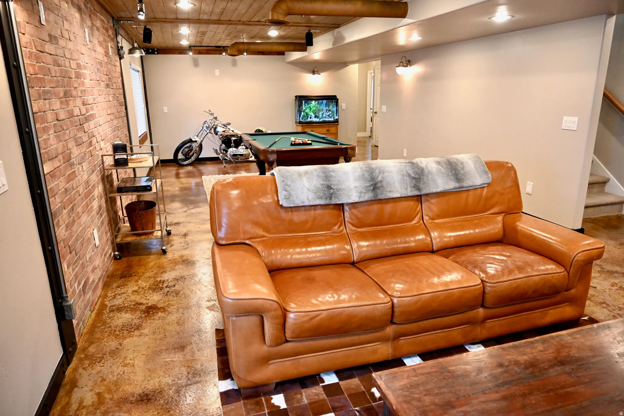Exposed brick accent wall and concrete-finish flooring define this versatile space
