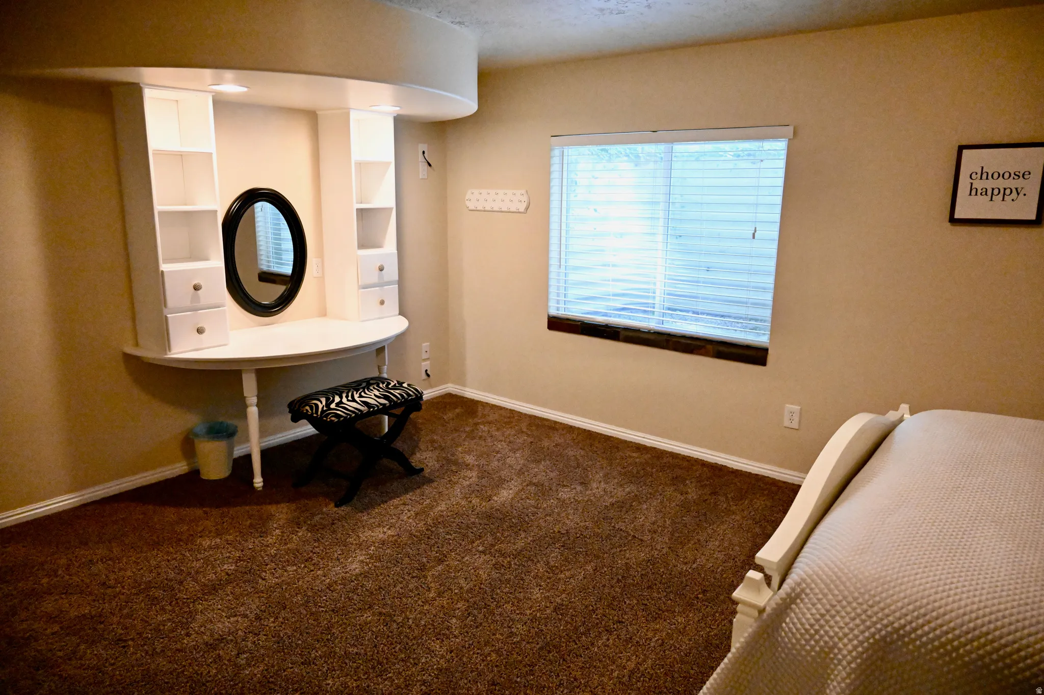 Built-in vanity with shelving and drawers, featuring an oval mirror and recessed lighting
