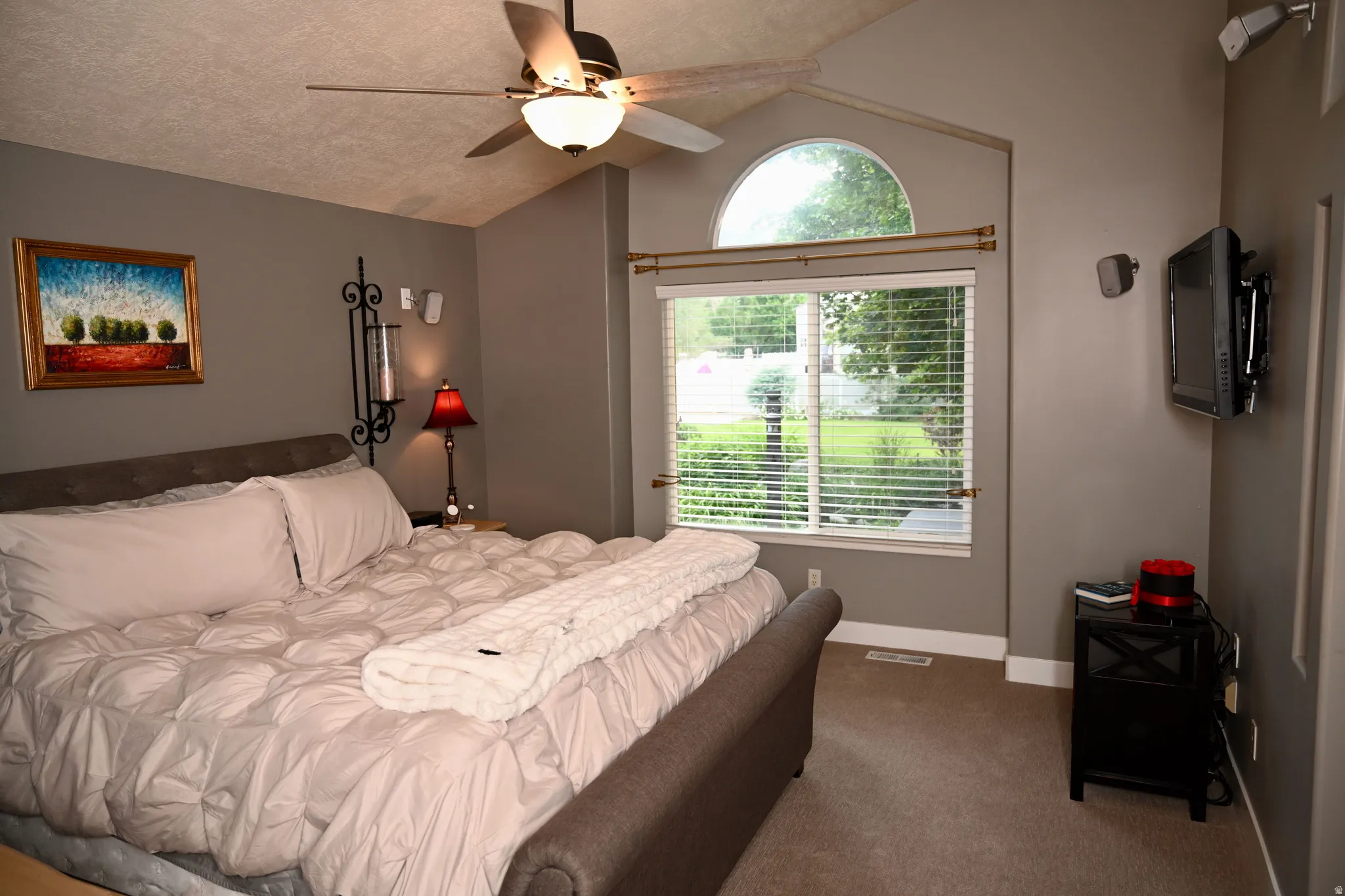 Vaulted ceiling featuring a ceiling fan with integrated lighting