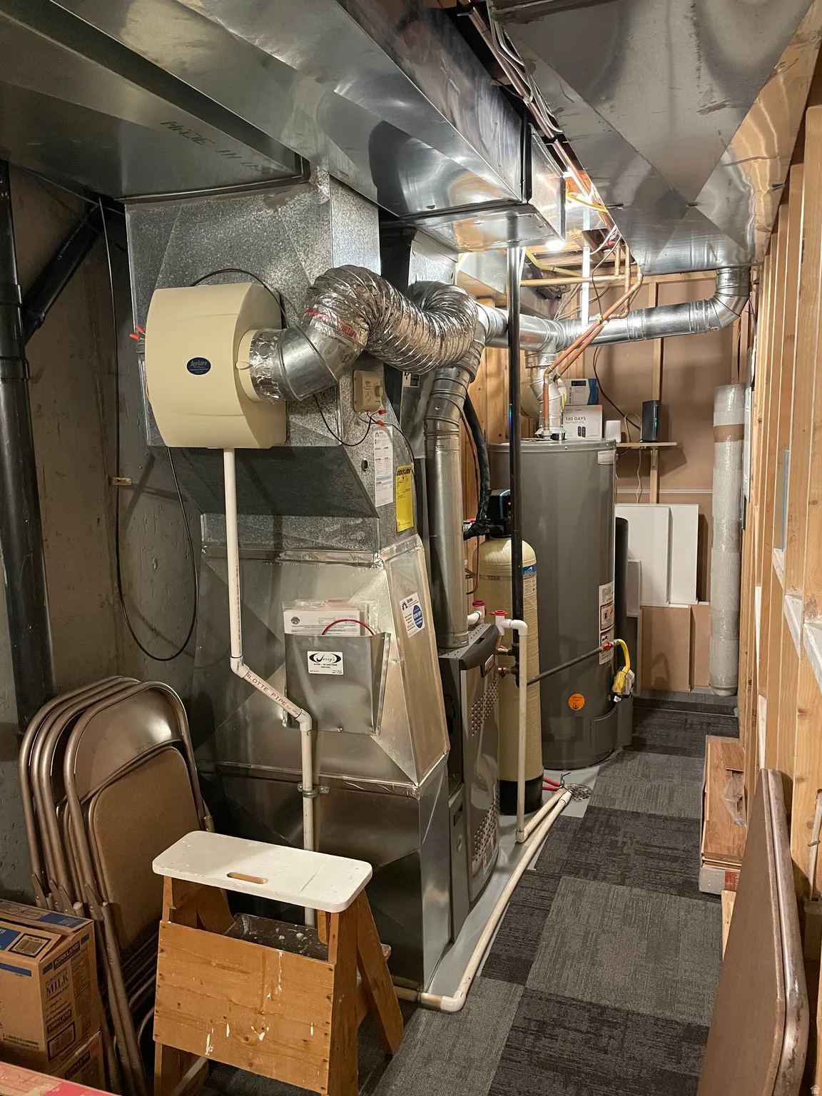 Mechanical room featuring a furnace with an attached humidifier, a water heater, and a water softener system