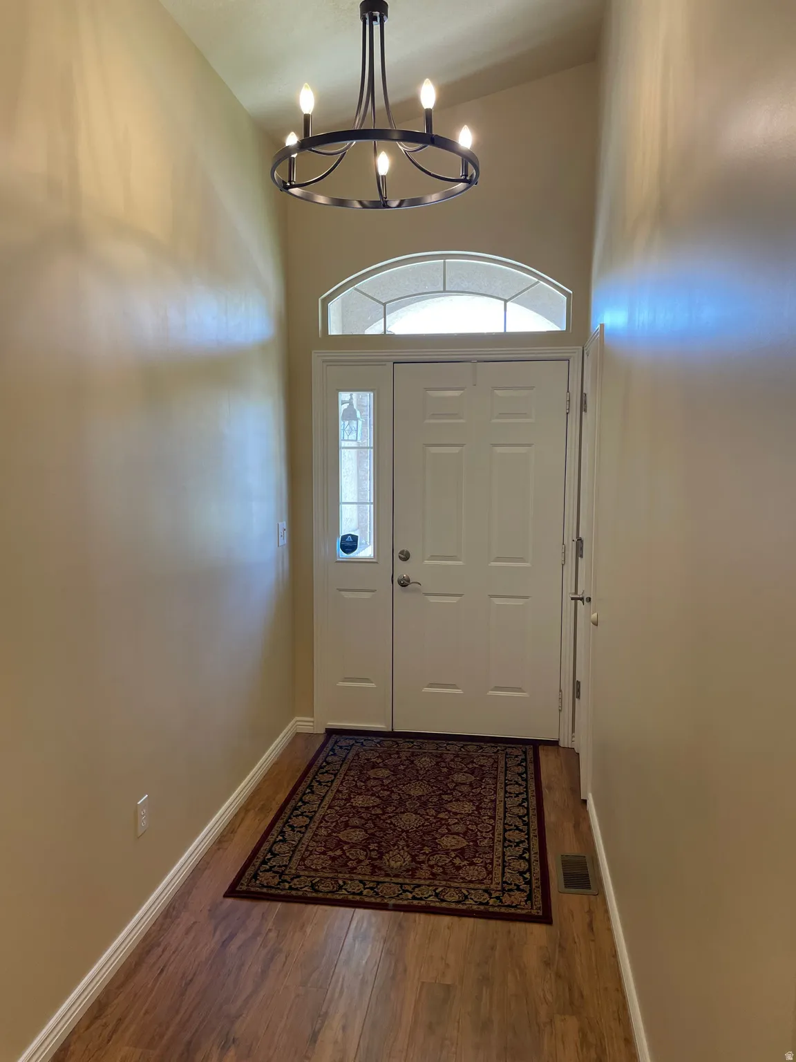 Entryway featuring vaulted ceilings and wood-finish flooring