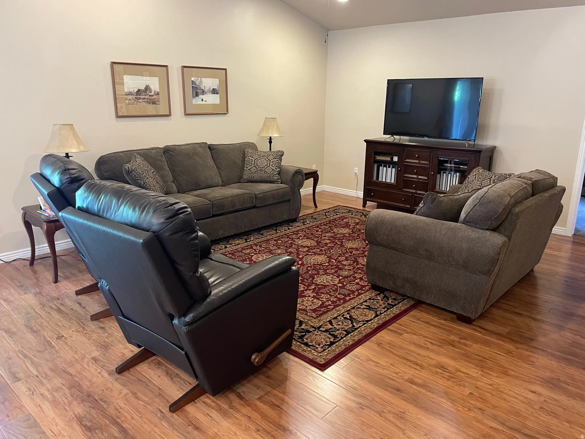 Spacious living area featuring wood-finish flooring, light-toned walls, and a recessed ceiling