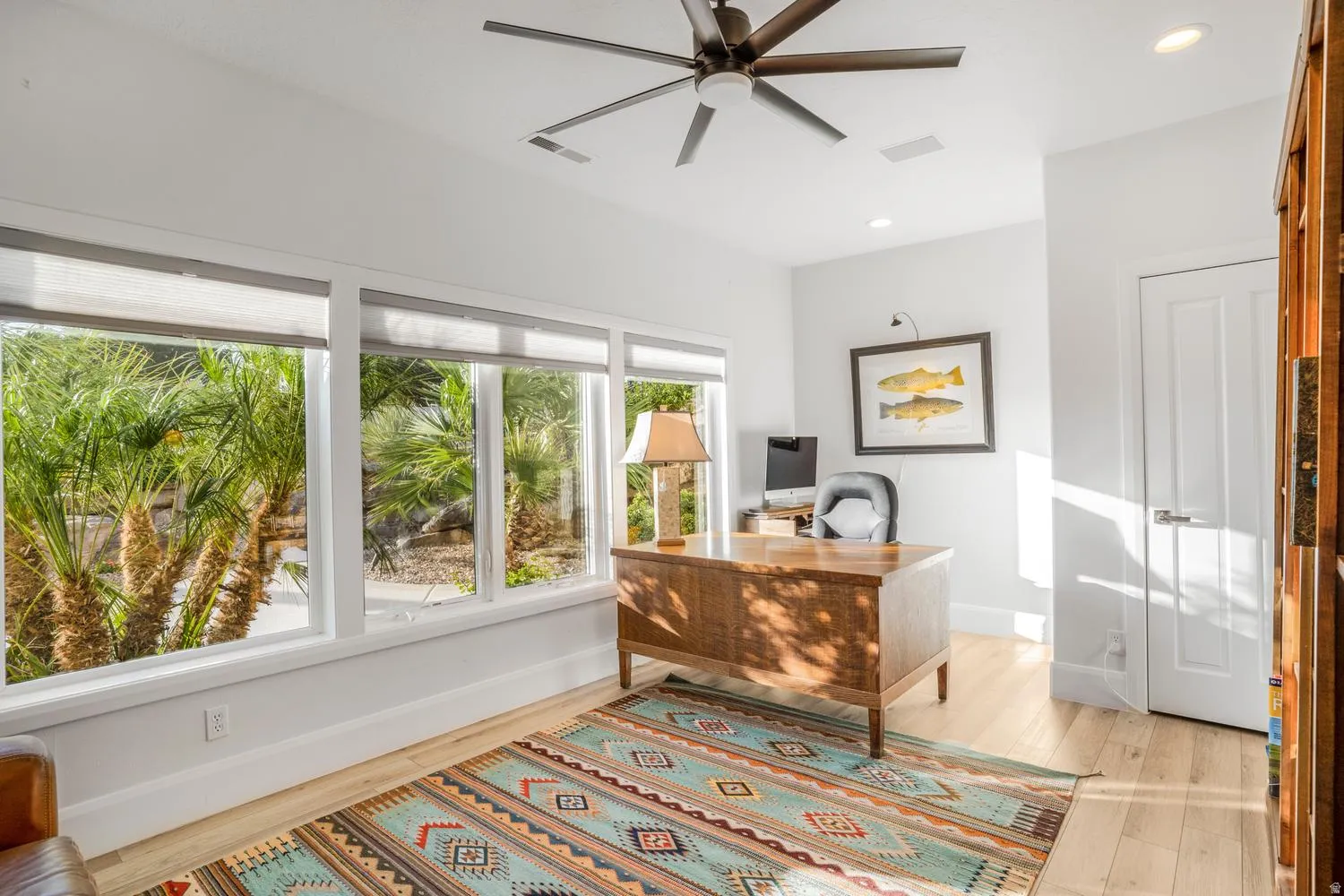 Bright room with a series of large windows overlooking tropical foliage