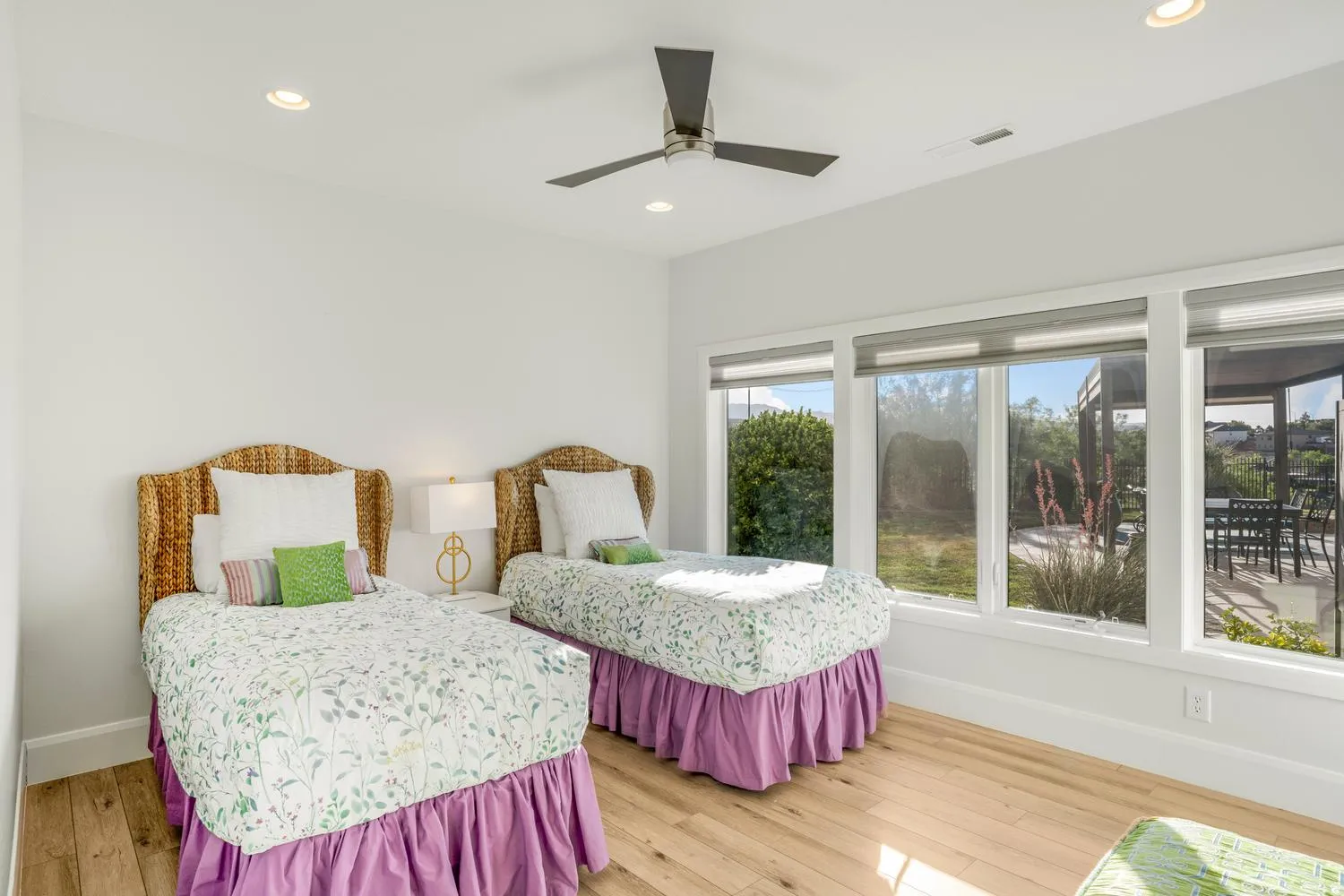 Bright room featuring expansive windows with roller shades, wood-finish flooring, recessed lighting, and a ceiling fan