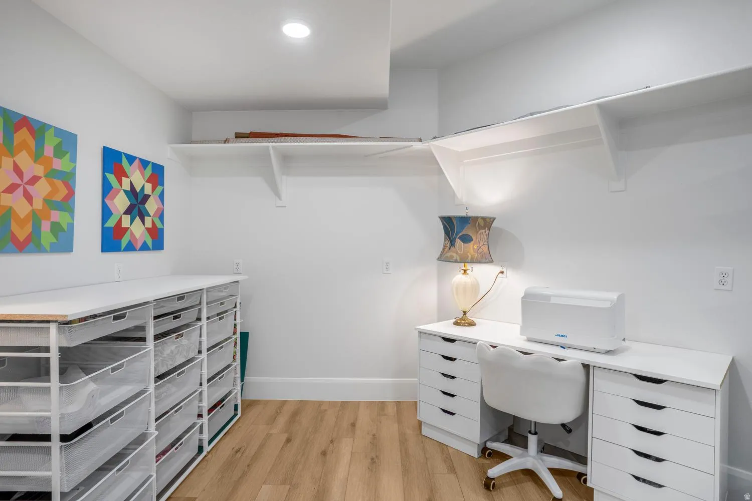 Dedicated workspace featuring wood-finish flooring, white walls, and recessed lighting