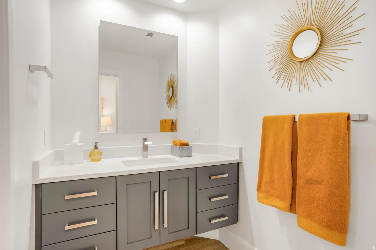 Modern bathroom featuring a floating vanity with a white countertop and integrated sink, brushed nickel faucet, and a large rectangular mirror