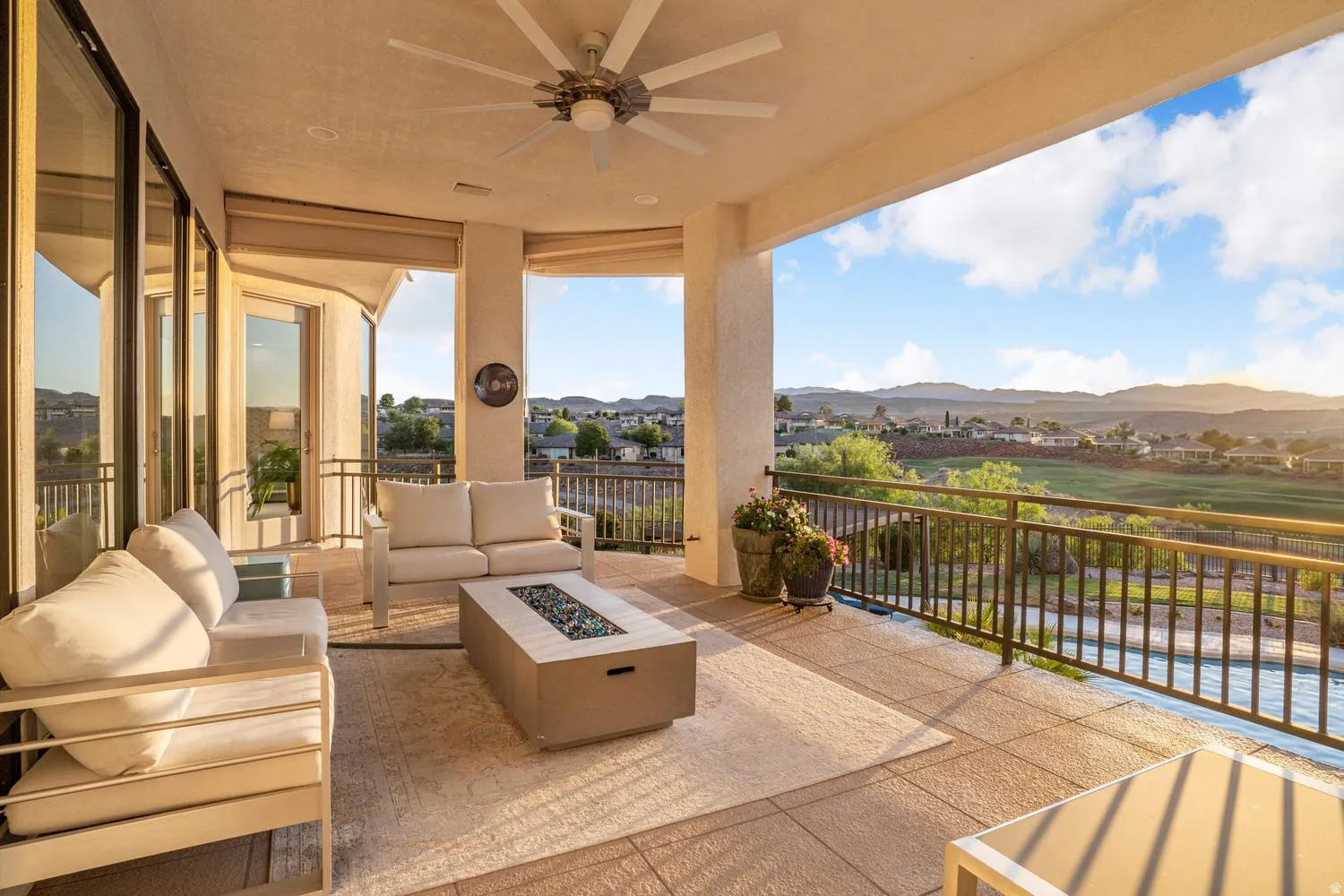 Expansive outdoor patio with a built-in ceiling fan, offering a broad landscape with distant mountains