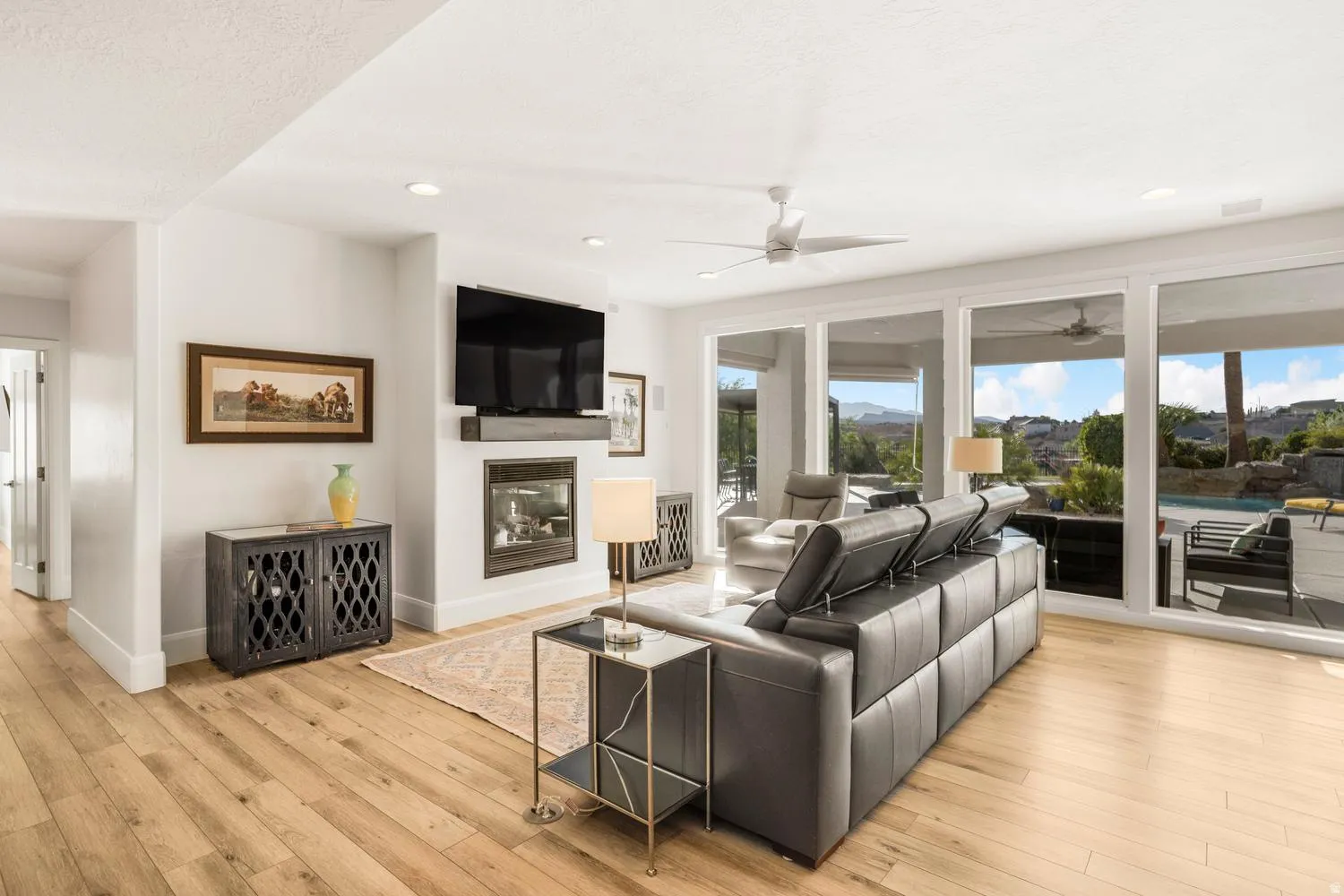 Spacious living area featuring wood-finish flooring, a contemporary fireplace, and recessed lighting