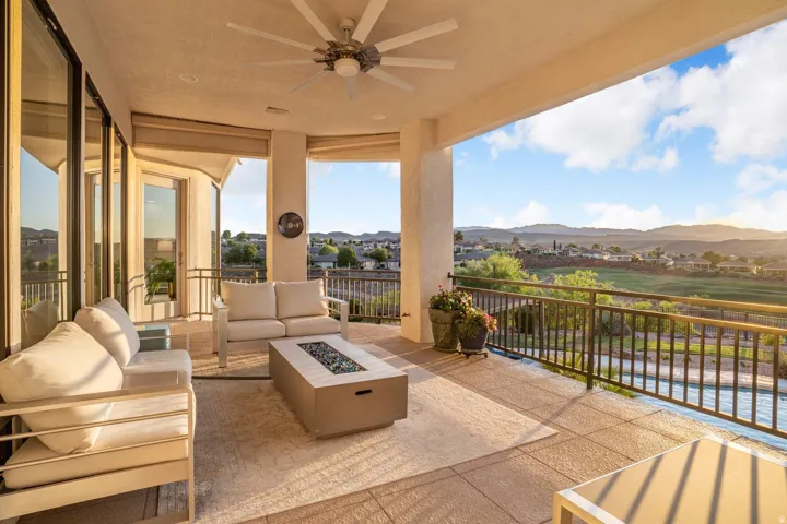 Expansive outdoor patio with a built-in ceiling fan, offering a broad landscape with distant mountains
