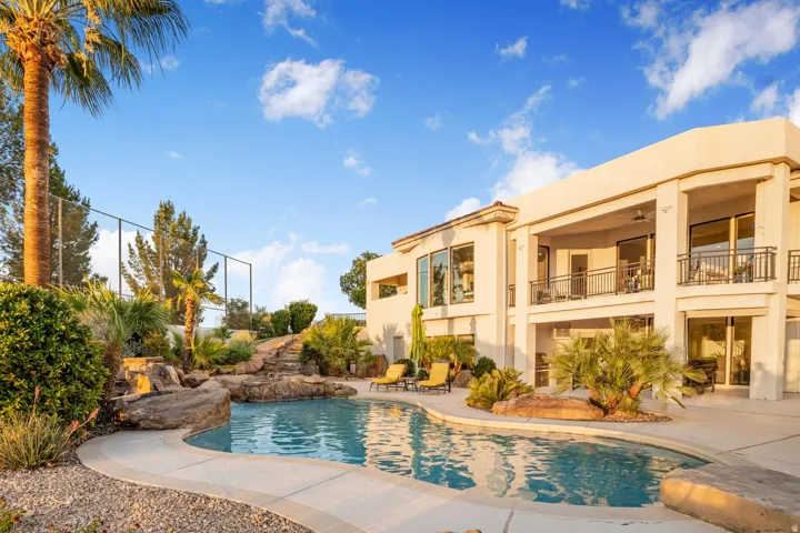 Custom-shaped swimming pool featuring a rock waterfall and integrated spa