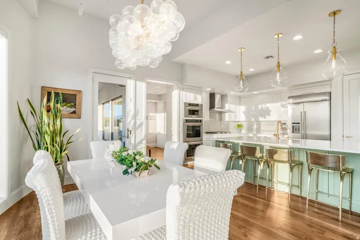 Open-concept dining and kitchen area featuring wood-finish flooring