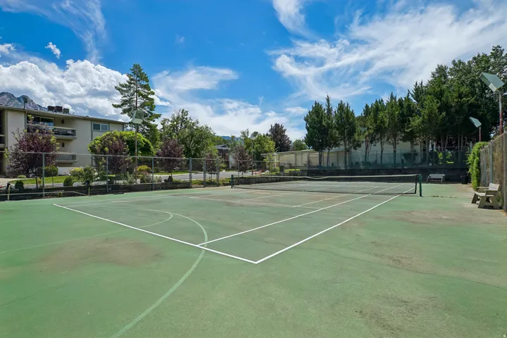 Community tennis court featuring a green playing surface and white line markings