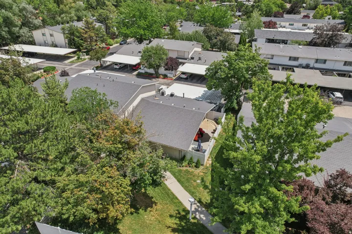 Residential complex featuring multiple townhouse-style buildings with gray shingle roofs
