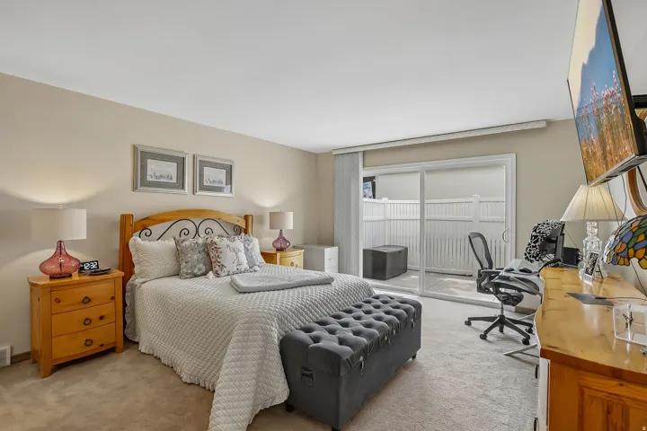 Soft neutral wall tones featuring a sliding glass door providing access to an outdoor patio