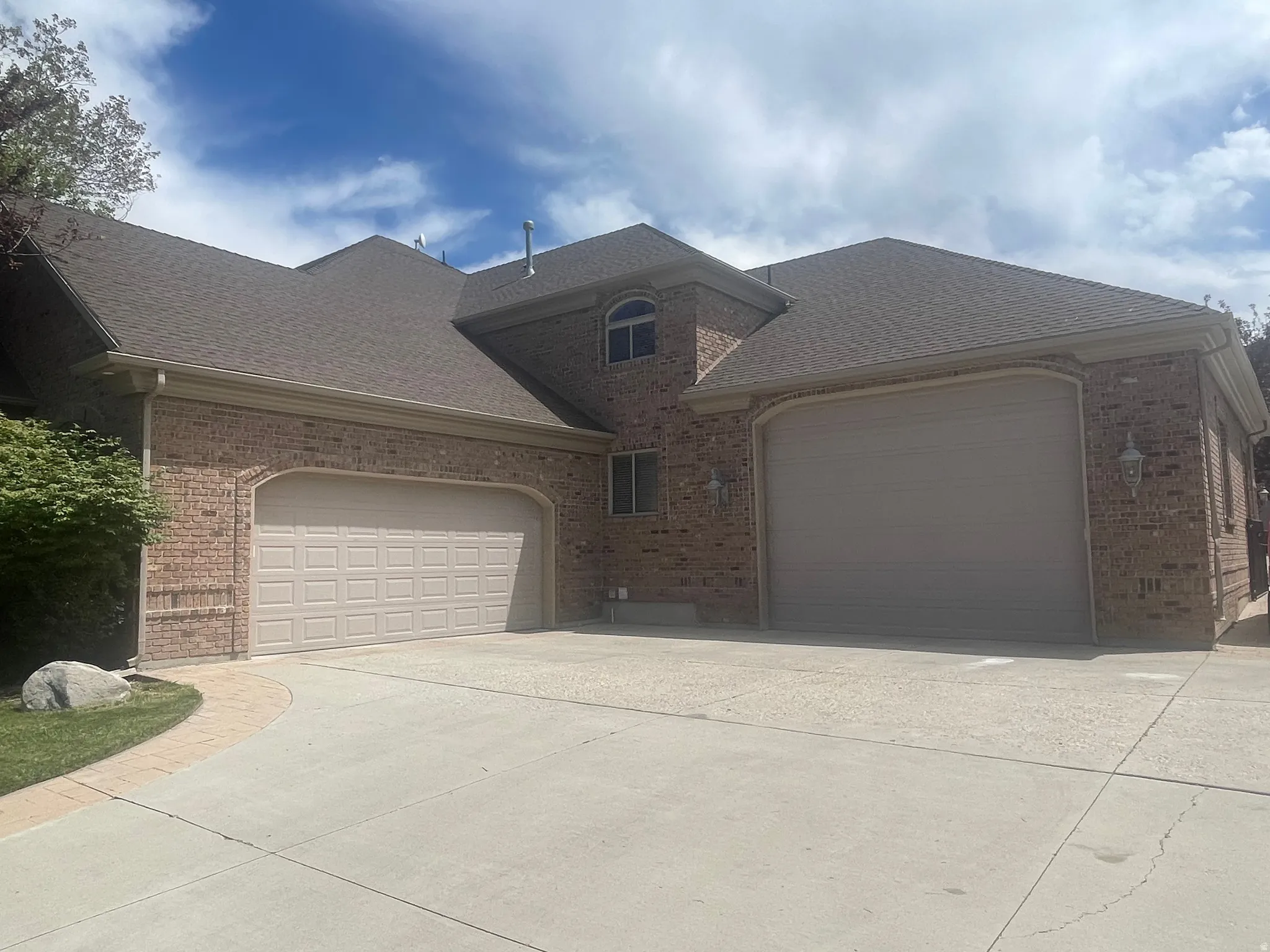 Brick exterior featuring two integrated garage doors with arched brick surrounds
