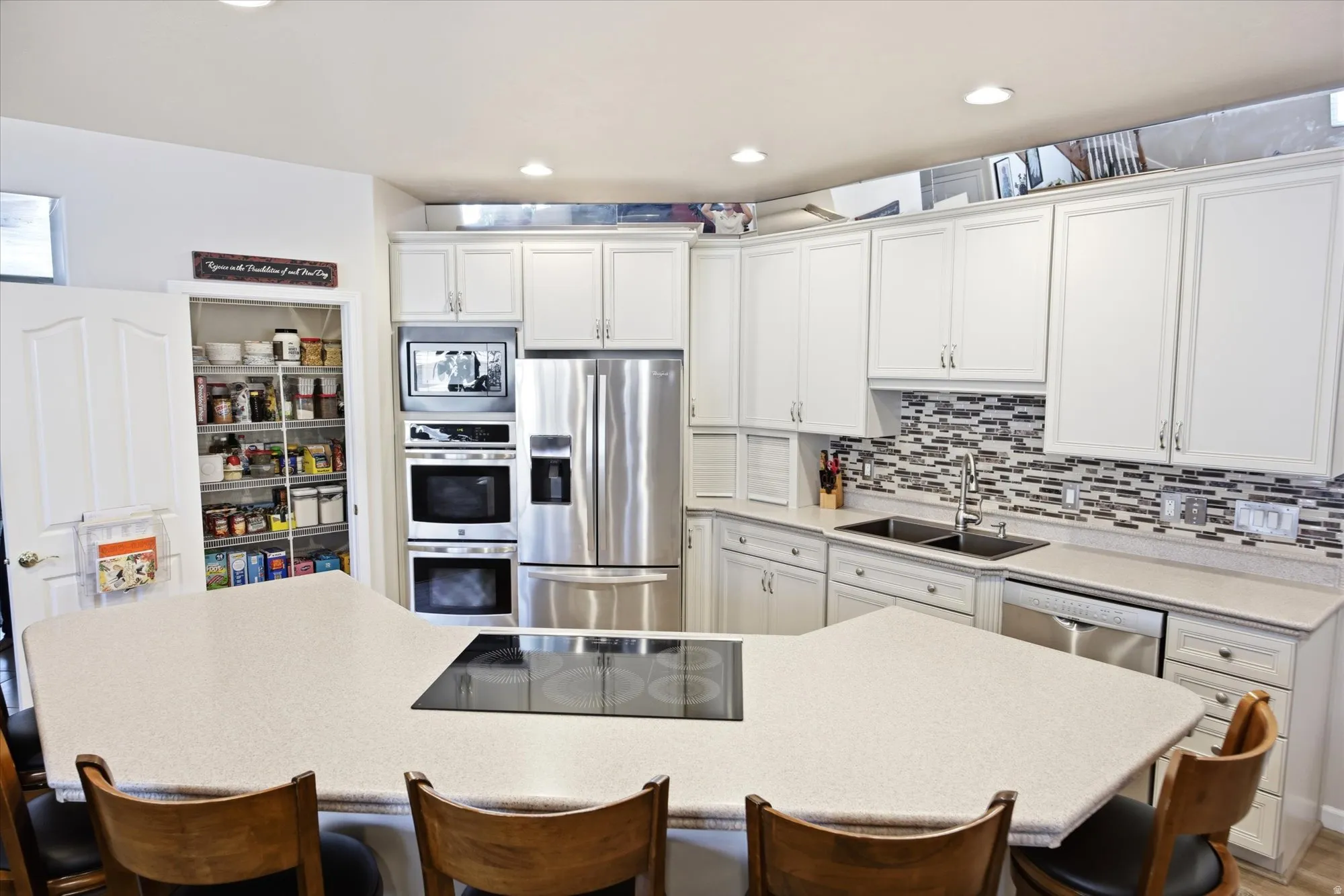 Modern kitchen featuring white cabinetry, light-toned countertops, and a mosaic tile backsplash