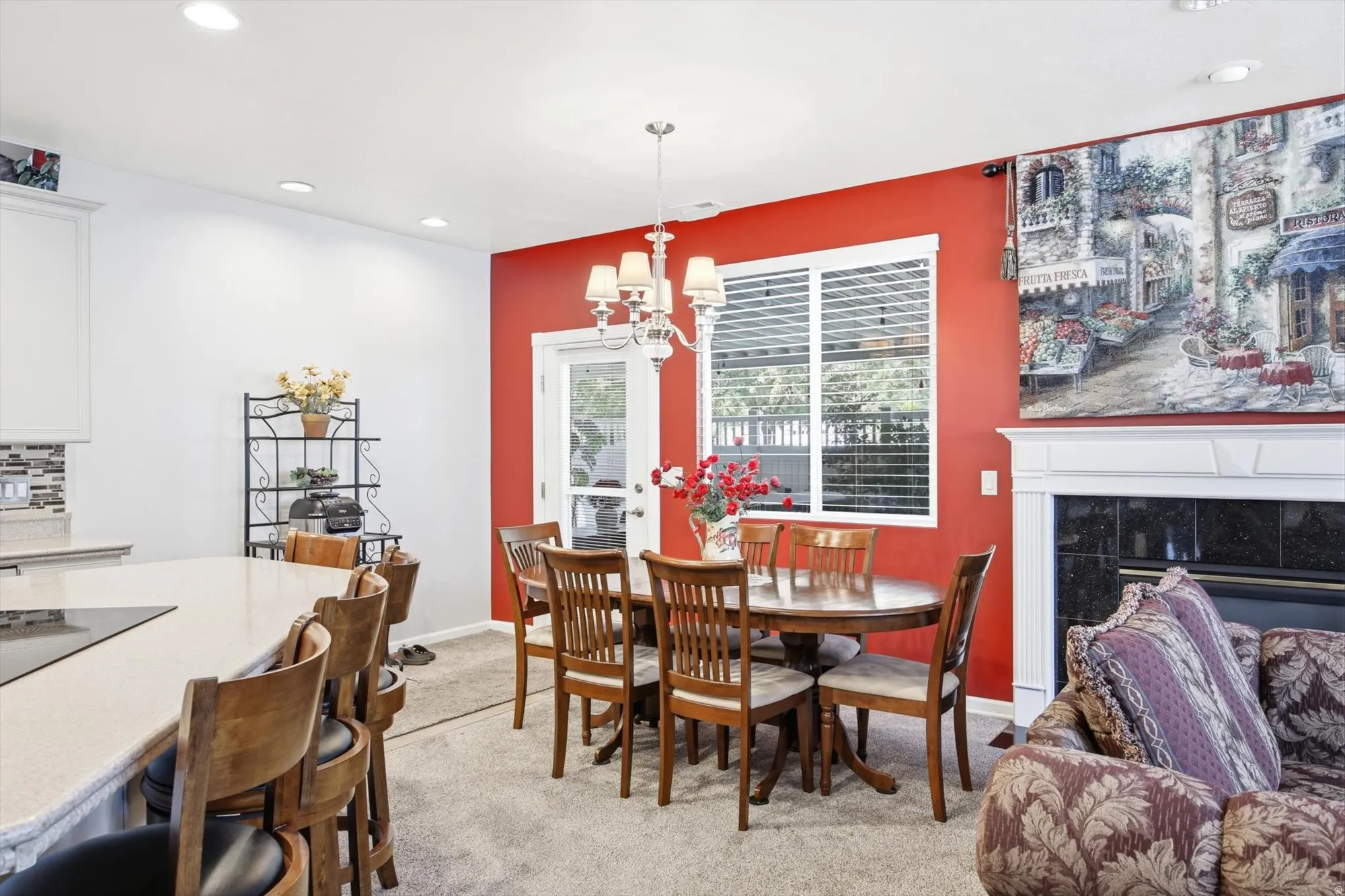 Dining area featuring a chandelier, large window with blinds, and a door providing exterior access