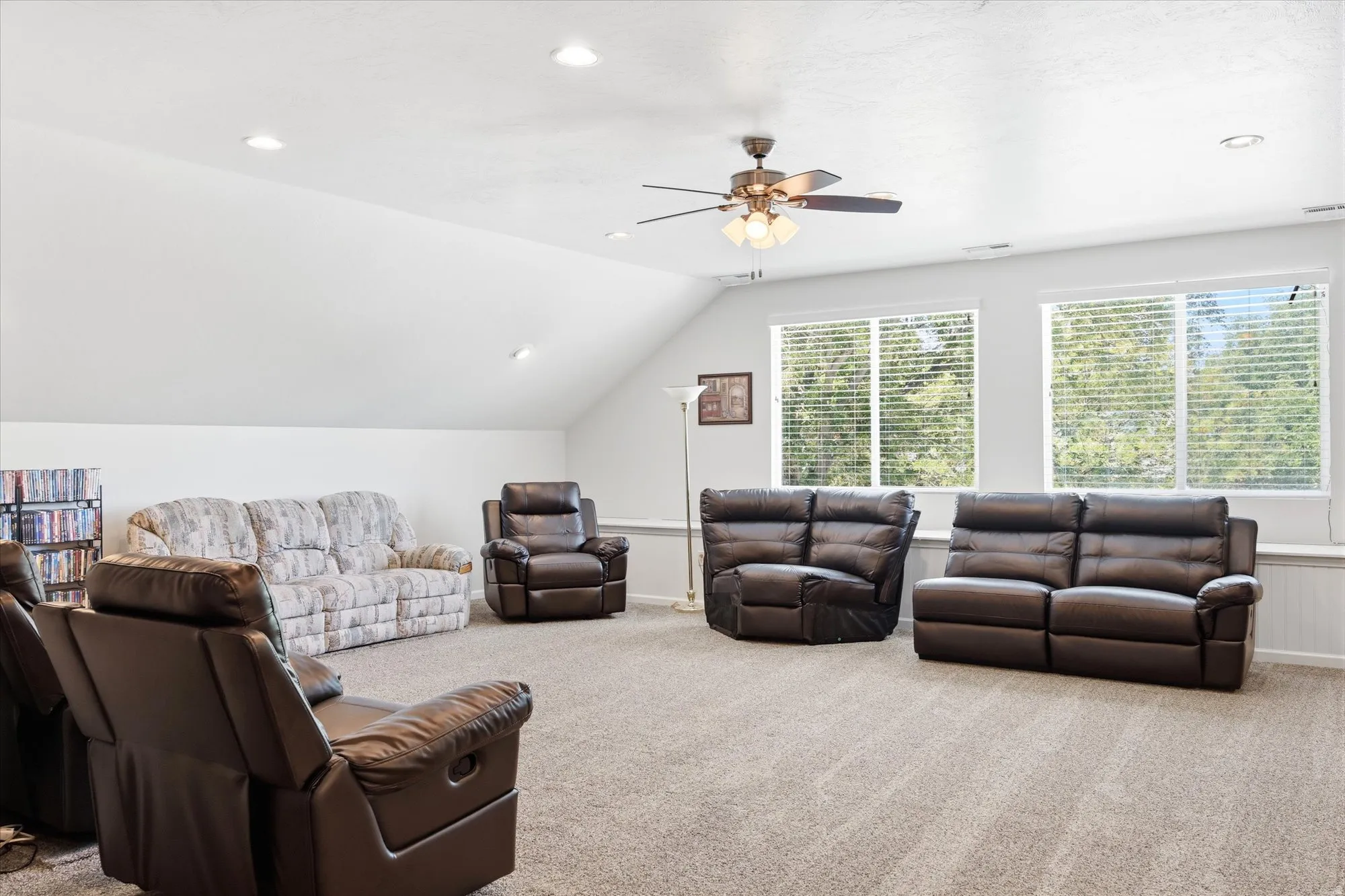Spacious bonus room featuring vaulted ceilings, recessed lighting, carpet flooring, a ceiling fan, and multiple windows with blinds