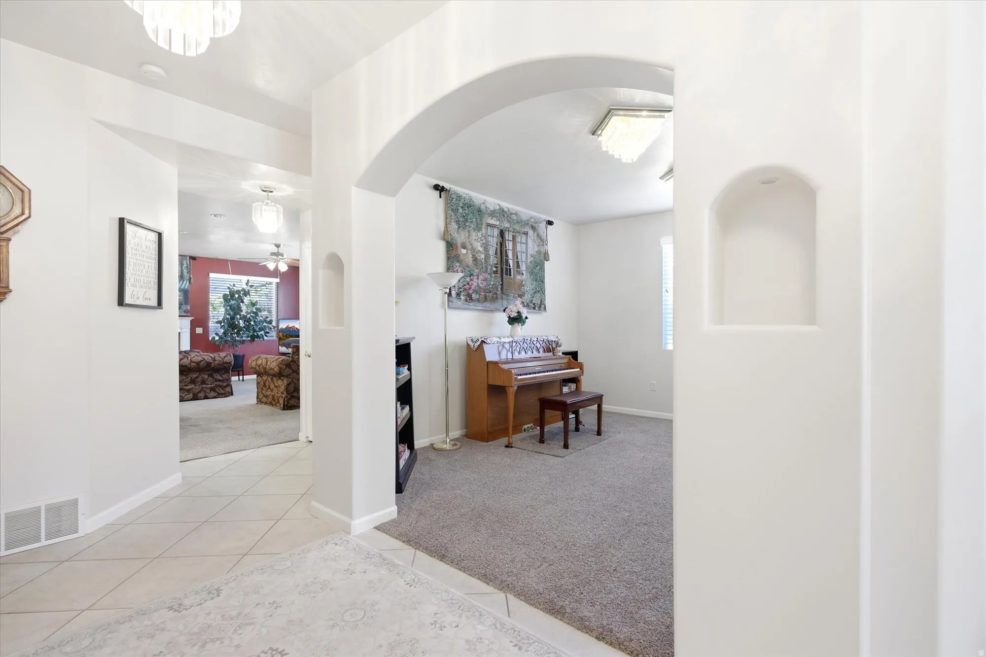 Arched doorways and recessed wall niches define the interior, featuring a mix of tile and carpet flooring