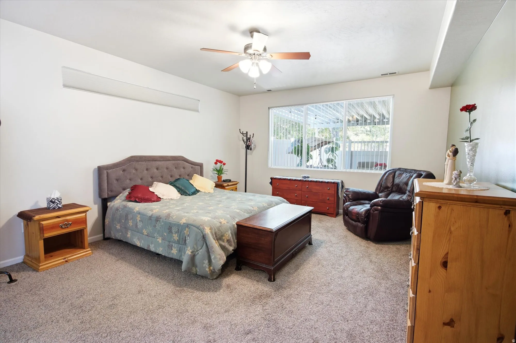 Spacious room featuring neutral carpeting and a ceiling fan with integrated lighting