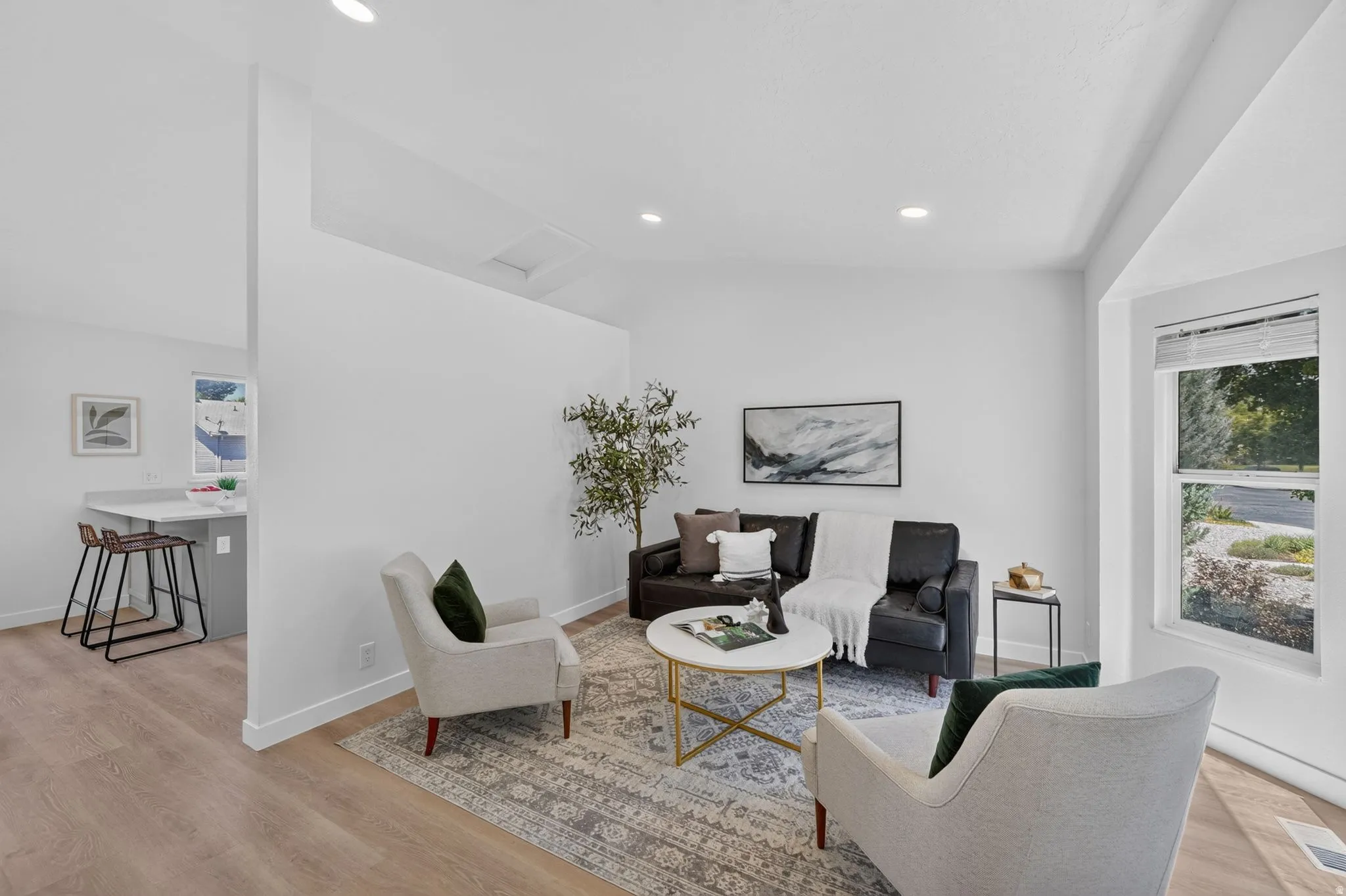 Open-concept living space featuring wood-finish flooring, recessed lighting, and a neutral color palette