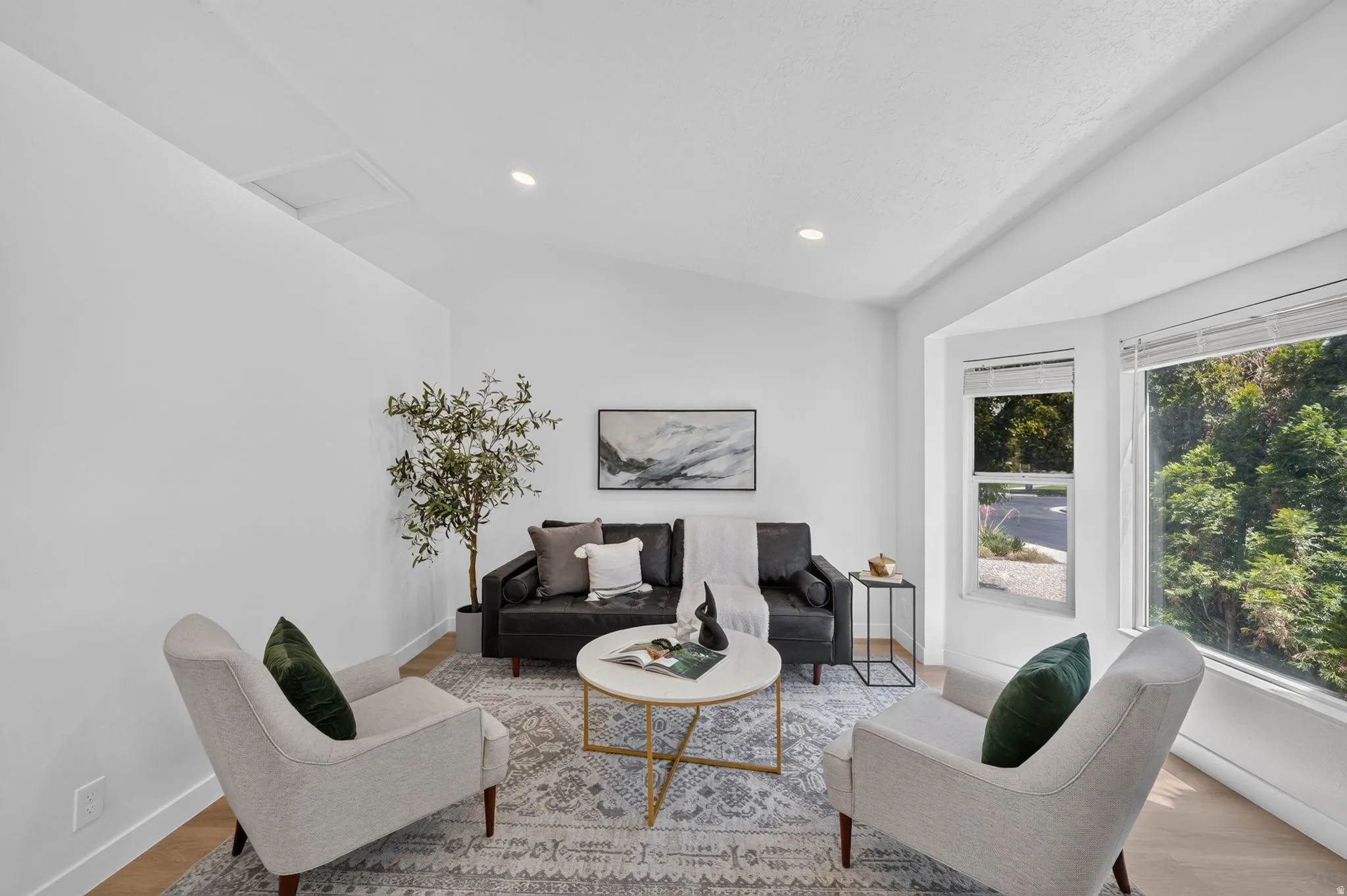 Bright living area featuring wood-finish flooring, recessed lighting, and a bay window