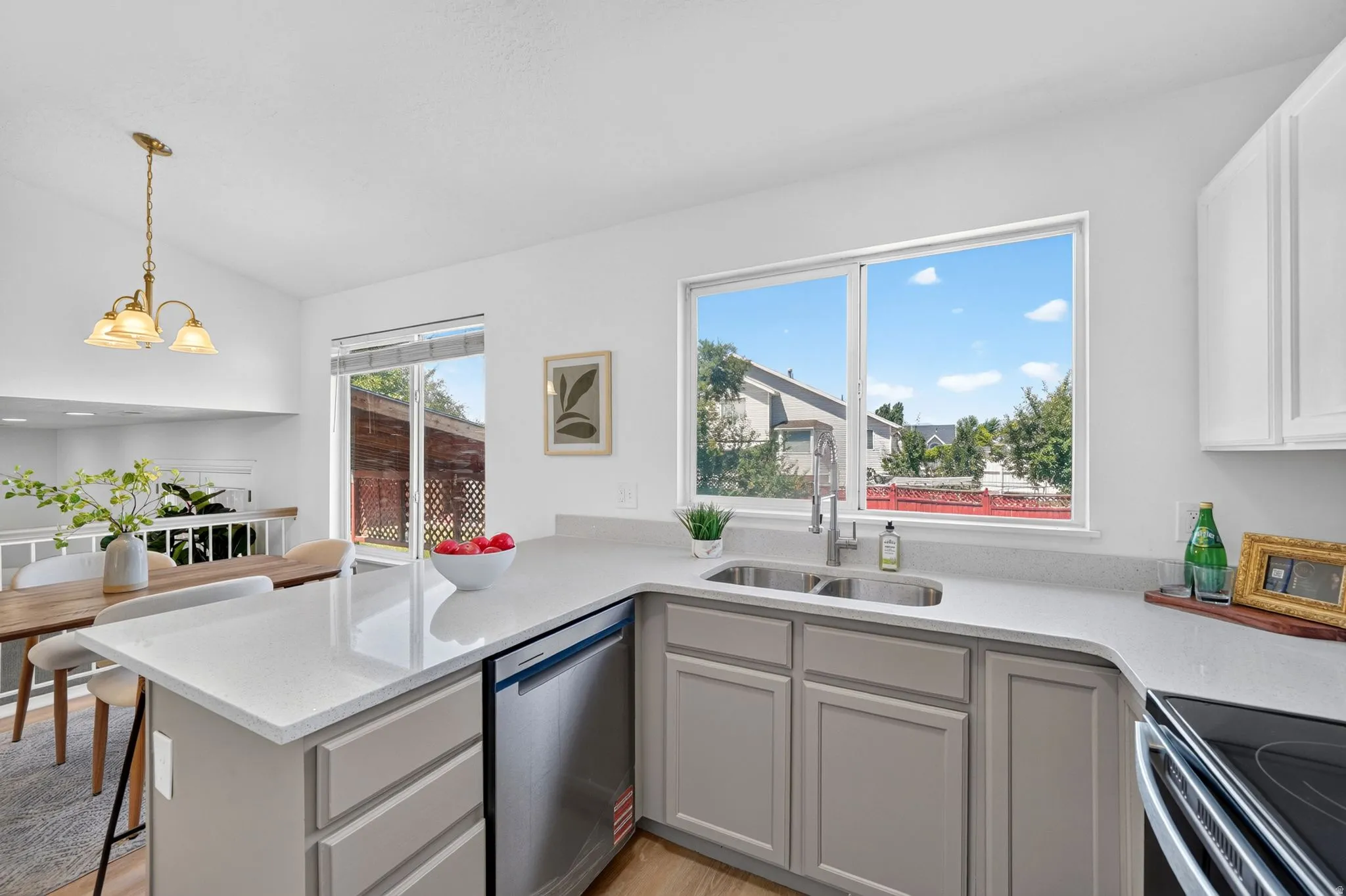 Modern kitchen featuring light gray cabinetry, white countertops, and stainless steel appliances