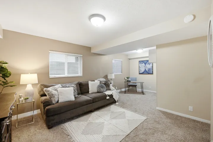 Carpeted living space featuring recessed lighting and neutral wall tones