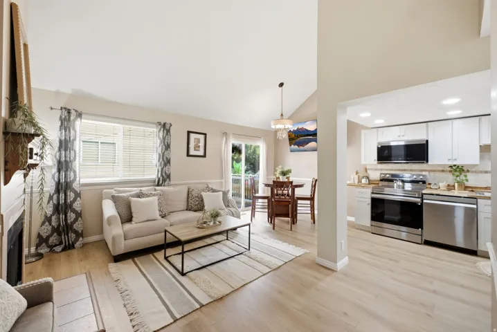 Open concept living space featuring vaulted ceilings and light wood-finish flooring
