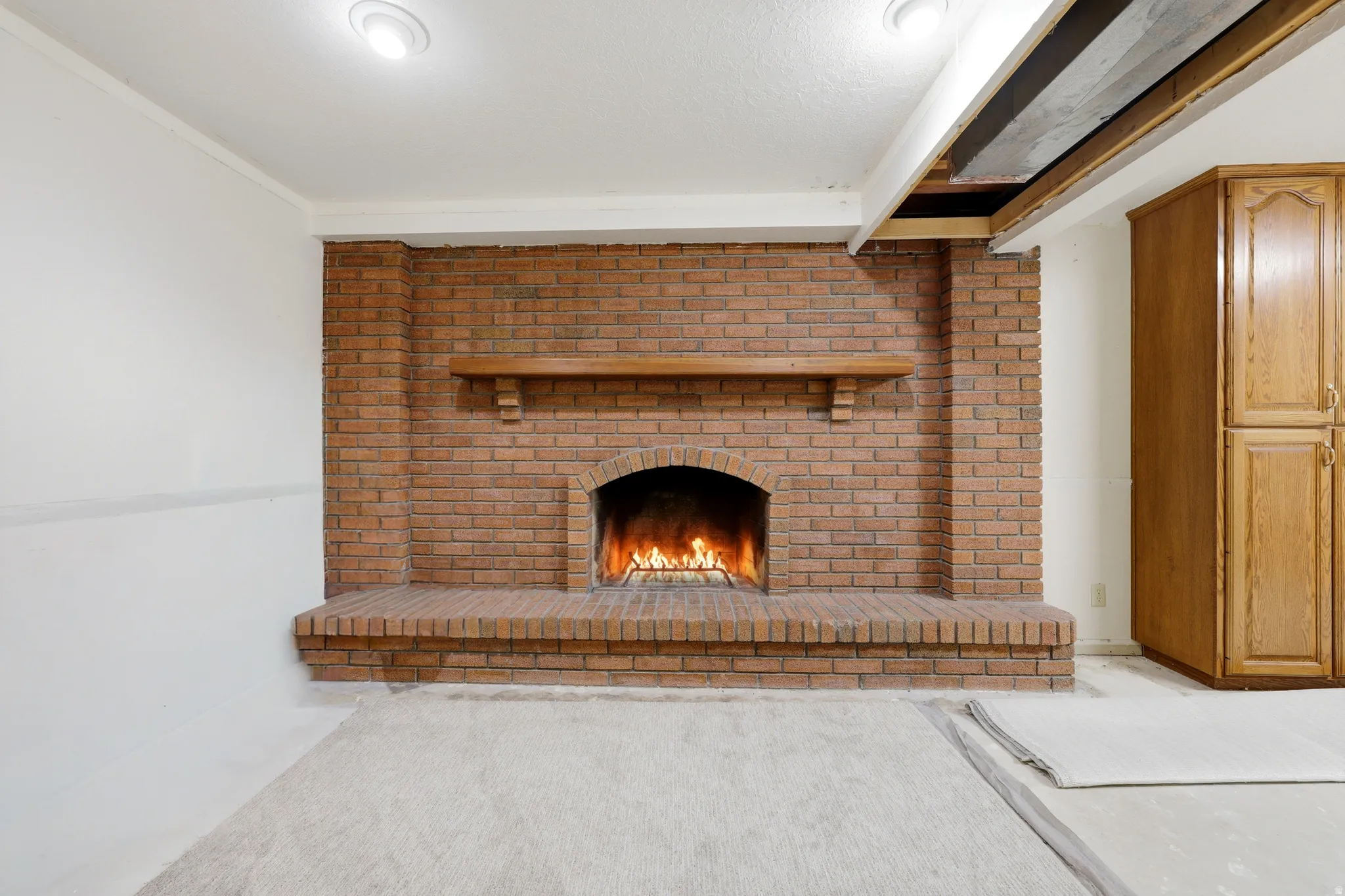 Brick fireplace with an arched firebox and a wood mantel